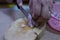 Close-up pictures of people. The chefs are slicing red onions, small vegetables, herbs on a wooden cutting board.