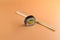 Close-up of a piece of sushi with chopsticks on orange background