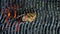 Close-up of a piece of veal or beef on the grill held by iron tongs, top view, fire and smoke