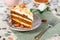 Close-up the piece of vegetarian carrot cake with almonds on a saucer and a fork near.