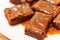 Close-up on pieces of brownie with salted caramel sauce