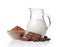 Close-up pieces of chocolate bar with cocoa beans, bowl of cocoa powder and glass jug of milk