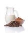 Close-up pieces of chunk black chocolate with glass bowl of cocoa powder andï¿½jug of milk