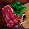 Close up of pieces of striploin served with parley on wooden table