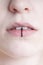 Close-up of pierced female lips with vertical labret piercing or lip ring