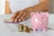 Close-up of a piggy bank and coins and paper euros in female hands on the office table. crisis and inflation. Cost Management