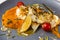 Close-up pike perch fillet with creamy pumpkin puree and seeds, almond flakes, fried cherry tomatoes and thyme, lunch menu of