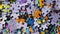 Close-up on a pile of jigsaw puzzle pieces falling with colorful pieces of another jigsaw puzzle. Slow motion.