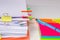 Close-up of a pile of paper with colored post its and a pen.