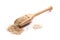 Close-up of pile of raw whole grain sesame seeds in a wooden spoon on white background