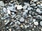 Close up pile of smooth small stones on black sand