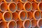 Close-up pile of stacked plastic orange pipes