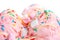close up of pink berry scoops ice cream strewed sprinkles, marshmallows and icing isolated on white
