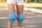 Close-up of pink and blue protective knee pads on girl\'s legs