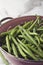 Close up of a pink colander with washed green beans