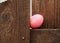 Close up of pink-dyed Easter egg with name of `Natalie` is hidden on a ledge on wooden fence