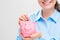 Close-up of a pink pig piggy bank in the hands of an economical
