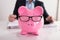 Close-up Of Pink Piggybank Wearing Spectacles