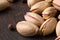 Close-up of pistachios and black pepper. Salted nuts on a black table background. Traditional appetizers. Copy space.