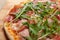 Close up of Pizza with prosciutto parma ham and  arugula salad rocket