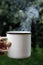 Close up of plain white cup with hot drink with steam over it