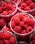 Close-up plastic glass with raspberries ready to take away. Quick, healthy snack from berries in convenient container