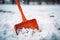 Close-up of a plastic snow shovel while clearing a sidewalk