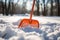 Close-up of a plastic snow shovel while clearing a sidewalk