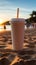 Close up plastic white coffee cup with black straw on sand of beach at sunset or sunrise sunlight