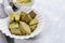 Close up plate as shell with treats containing matcha, bowl of Matcha powder,napkin on light grey background