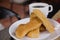 Close up of a plate of bisquit typical andean food region, with a blurred cup of coffe behind, sponge biscuits of