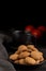 Close-up of plate with cookies, black cup and tangerines on dark table, black background,