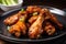 Close-up of a plate of crispy chicken teriyaki wings, hot and fresh out of the oven, served with a side of dipping sauce