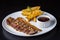 Close-up of a plate of food, containing a piece of grilled meat and a side of golden french fries