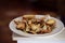 Close up of a plate of freshly cooked Mediterranean crab and white bread standing against a dark background