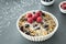 Close up of a plate with muesli, raisins, raspberries and coconut shreds