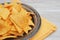 Close up Plate with Nachos with Cheese. Orange Napkin and Gray Rustic Table.