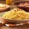 Close up of a plate of spaghetti carbonara on a wooden table