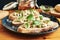 Close up on a plate of toasts with roquefort cheese, walnuts, honey and basil. Selective focus