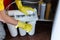 Close up Plumber in yellow household gloves changes water filters. Repairman changing water filter cartridges in kitchen