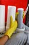 Close up Plumber in yellow household gloves changes water filters. Repairman changing water filter cartridges in kitchen