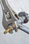 Close-up plumbers adjustable wrench tightens valve faucet.