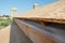 A close-up on plywood board, OSB used for roof sheathing installed on roof beams with blurred roofing construction in the