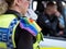 Close up police woman with rainbow colours painted on her face, and wearing a rainbow flag on her shoulder at the Gay Pride Parade