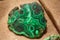 Close-up of polished malachite gemstone - green with wavy patterns used in jewelry