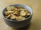 Close up poppy seed sesame crunchy crackers in gray bowl on wood