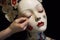 close-up of porcelain doll face being painted
