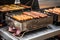 close-up of portable grill with sizzling hot dogs and hamburgers