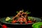 Close up of a portion of barbecued grilled ribs with a in sour sweet berry sauce served with green seedlings on the plate. concept