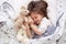 Close up portrait of adorable dark haired little girl calmly sleeping with sweet golden retriever pet in bedroom. Cute elementary